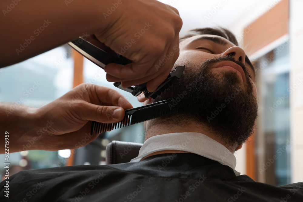Obraz premium Professional hairdresser working with client in barbershop, closeup