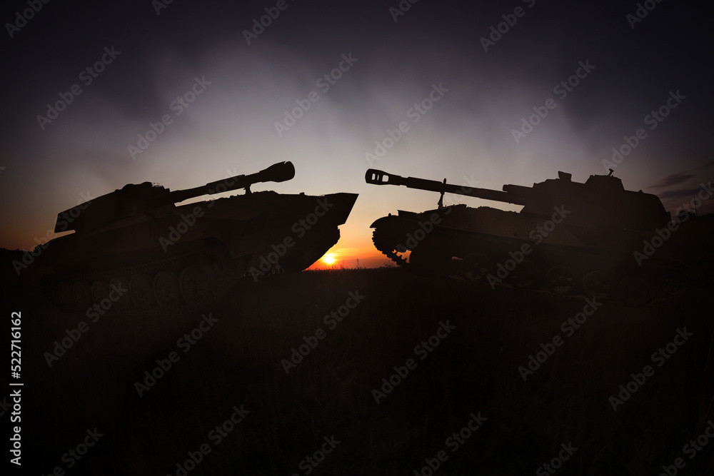 Naklejka premium Silhouettes of tanks on battlefield in night