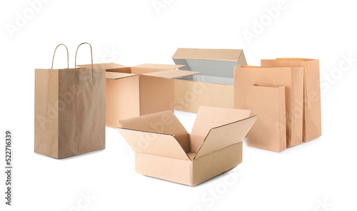 Set with different paper bags and cardboard boxes on white background