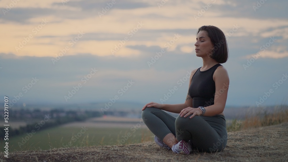 Peaceful millennial girl deeply meditating, doing breathing yoga exercises alone