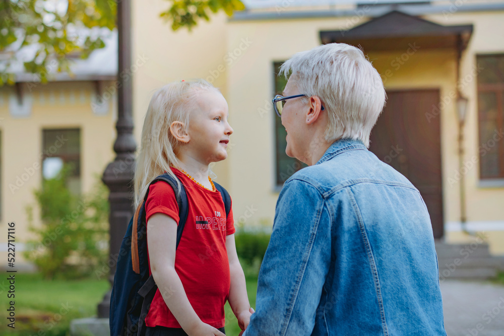 cute caucasian blonde little girl going to school. Mother having a conversation with child,