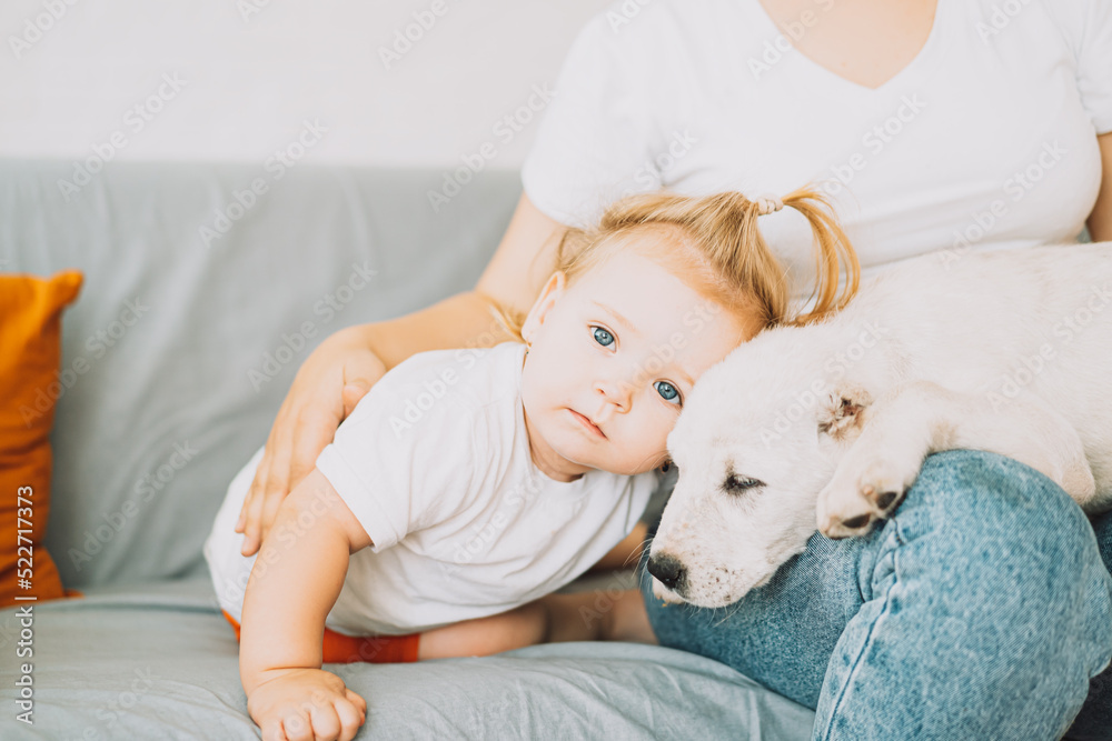 Girl hugging a puppy and a little girl.