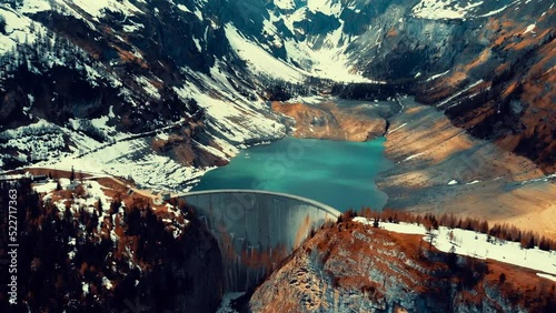 Aerial view of an arch dam on the Verzasca River in the Val Verzasca of Ticino, Switzerland. Snowy lake. Winter