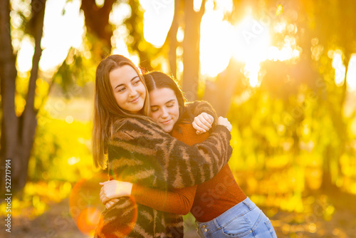 teenage girl comforting her friend with a hug photo