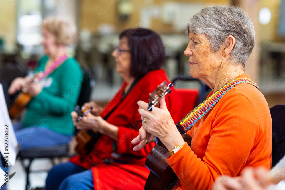 a colourful group of senior women playing ukulele a colourful group of senior women playing ukulele