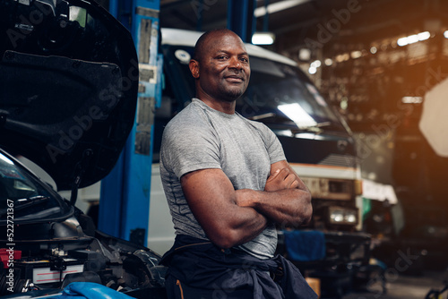 Portrait of man auto mechanic working at car repair shop with looking at camera. photo
