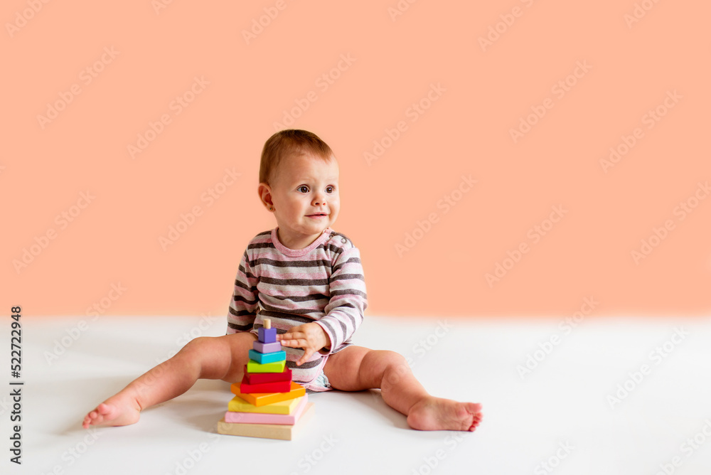 little child playing with toys on a plain background. Education and learning game concept with copy space. little child playing with toys on a plain background. Education and learning game concept with copy space.