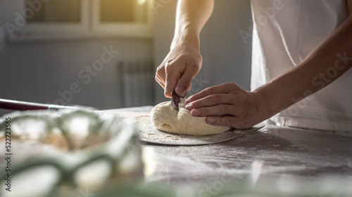 Baker cuts the dough with a knife before going into the oven for baking. Production of bakery products