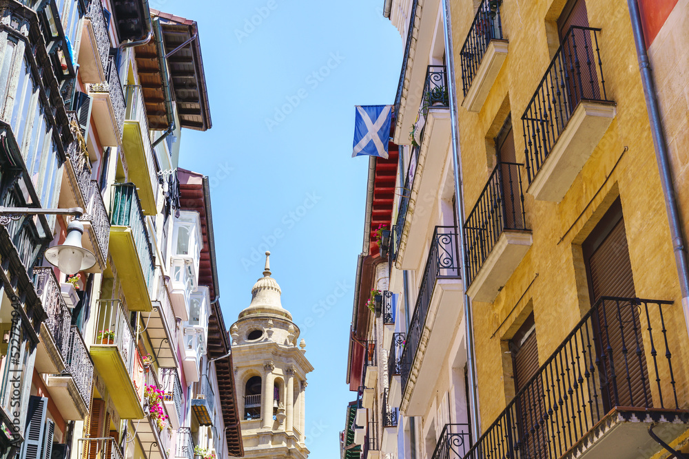 Obraz premium Aged church and houses on urban alley in Spain