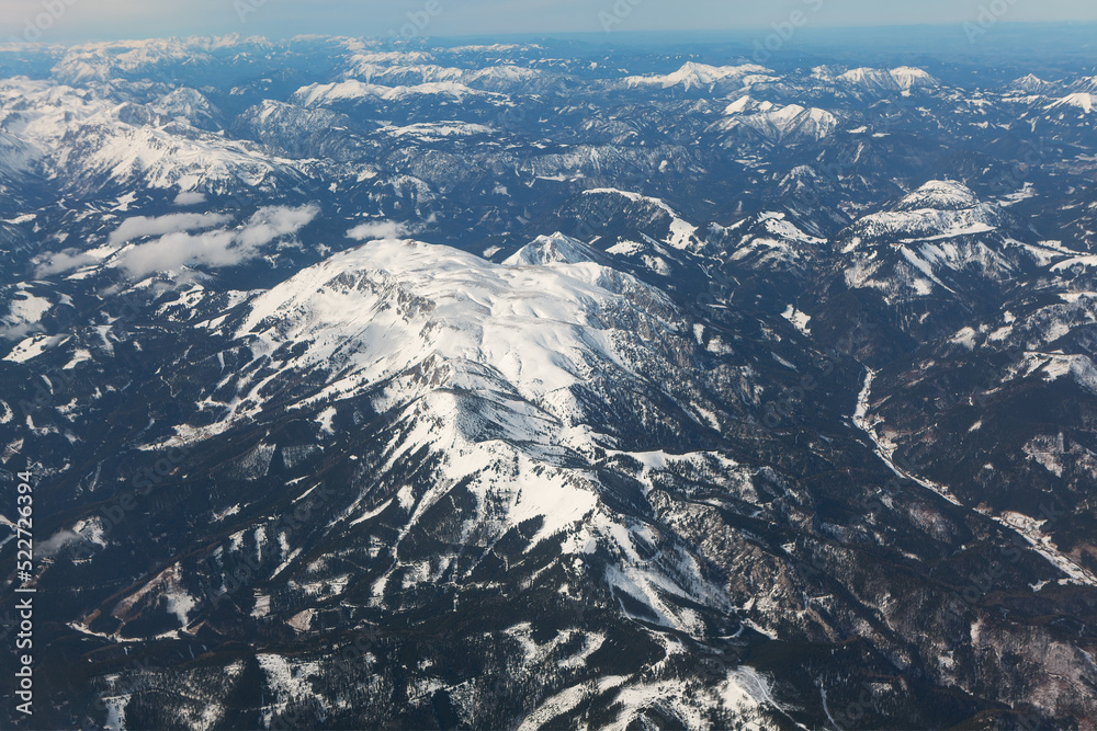 Black mountains covered by snow . Aerial view of snowy mountain peaks 