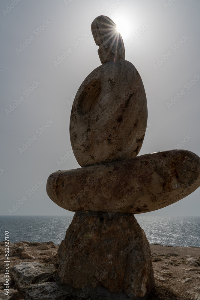 Sculpture symbol made of large pebbles against the blue sky Sculpture symbol made of large pebbles against the blue sky