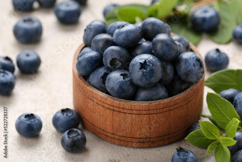Tasty fresh blueberries on light grey table, closeup
