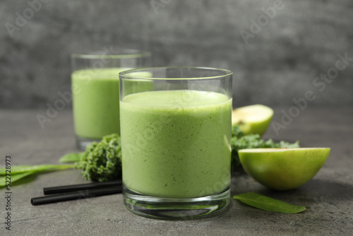 Tasty fresh kale smoothie on grey table, closeup