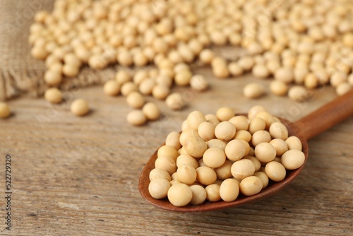 Natural soy beans on wooden table, closeup. Space for text