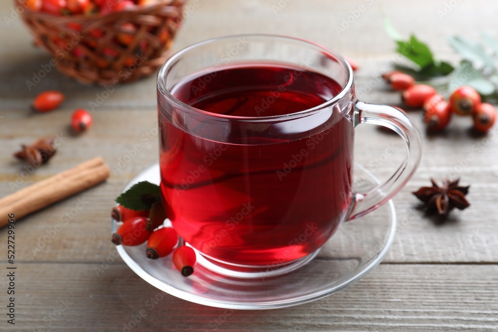 Aromatic rose hip tea and fresh berries on wooden table, closeup Aromatic rose hip tea and fresh berries on wooden table, closeup