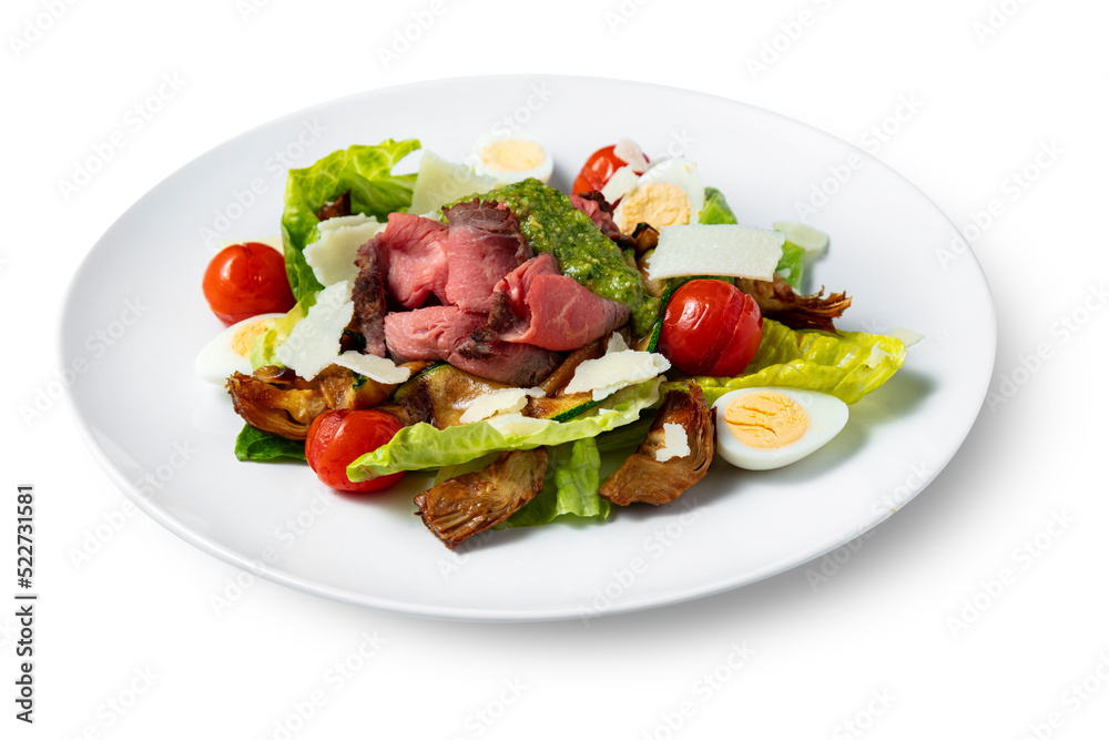 Salad with meat, pesto, tomatoes, boiled egg, lettuce, cheese and zucchini