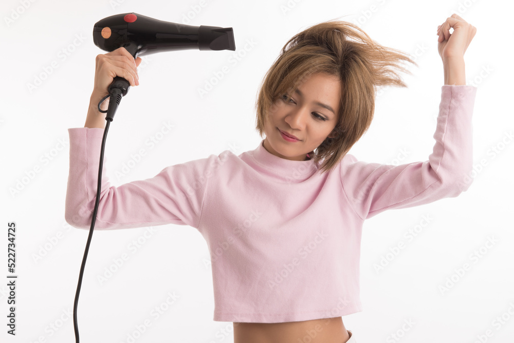 Asian woman uses hair dryer on white background. Asian woman uses hair dryer on white background.