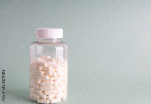 White pills and jar on the background. Side view.