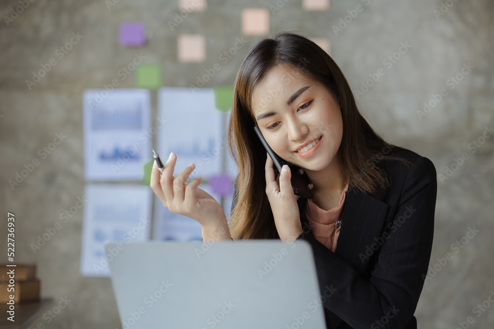 Beautiful Asian woman executives, business executives, marketing executives are talking on the phone with customers to contact the company for marketing. Marketing management concept. Beautiful Asian woman executives, business executives, marketing executives are talking on the phone with customers to contact the company for marketing. Marketing management concept.