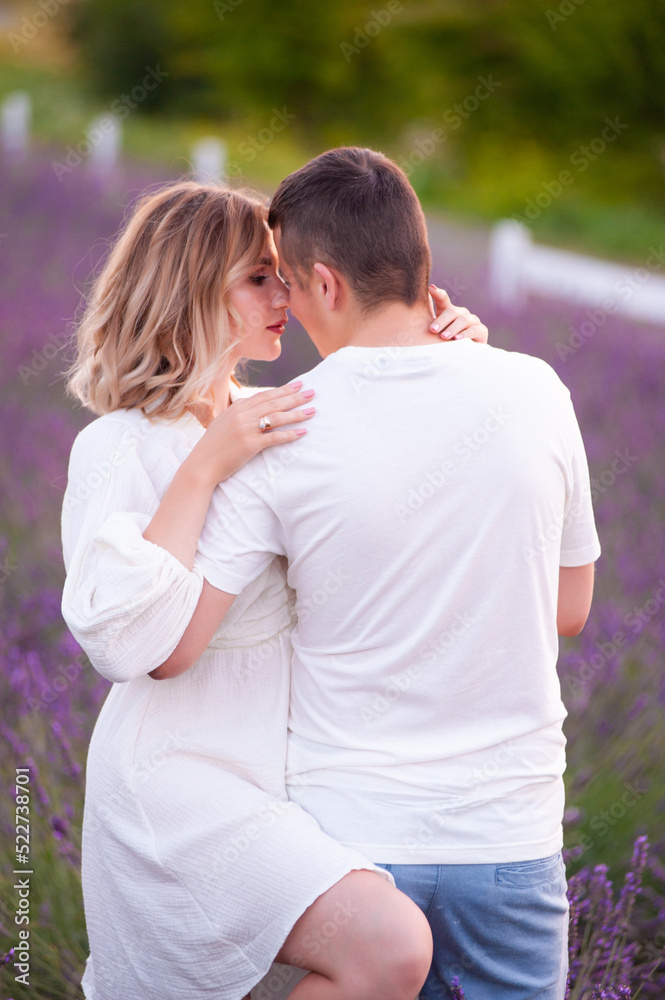 Obraz premium Young couple in love bride and groom, wedding day in summer. Enjoy a moment of happiness and love in a lavender field.