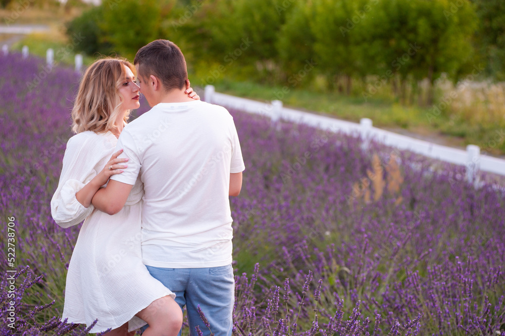 Fototapeta premium Young couple in love bride and groom, wedding day in summer. Enjoy a moment of happiness and love in a lavender field.