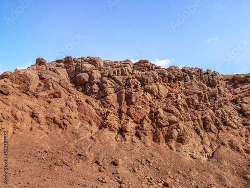 Orange-brown bare stone rock against the blue sky in the Sinai desert. Nature near Sharm El Sheikh  Egypt. Geological background with copy space