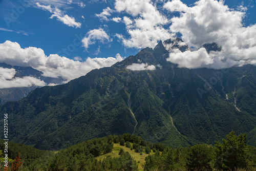 View of huge mountains with waterfalls and beautiful clouds in North Ossetia.