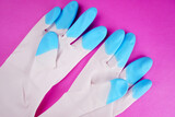 White and blue rubber gloves isolated on pink background.