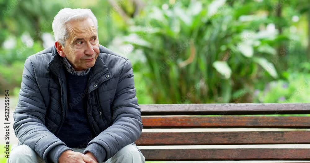Lonely, senior and depressed caucasian man sitting in the park looking bored from being retired. Sad, annoyed and.dissatisfied elderly person sitting on a bench. Upset and frustrated pensioner
