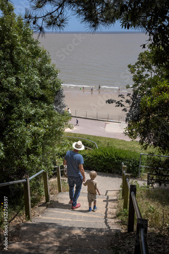 Walking to the beach with granddad. Boy and man. Stairs.Coast. Frinton on sea.. Northsea. England. Essex. UK. Great Brittain. photo