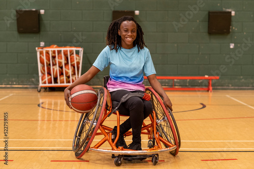Portrait of teenage girl in wheelchair on basketball court