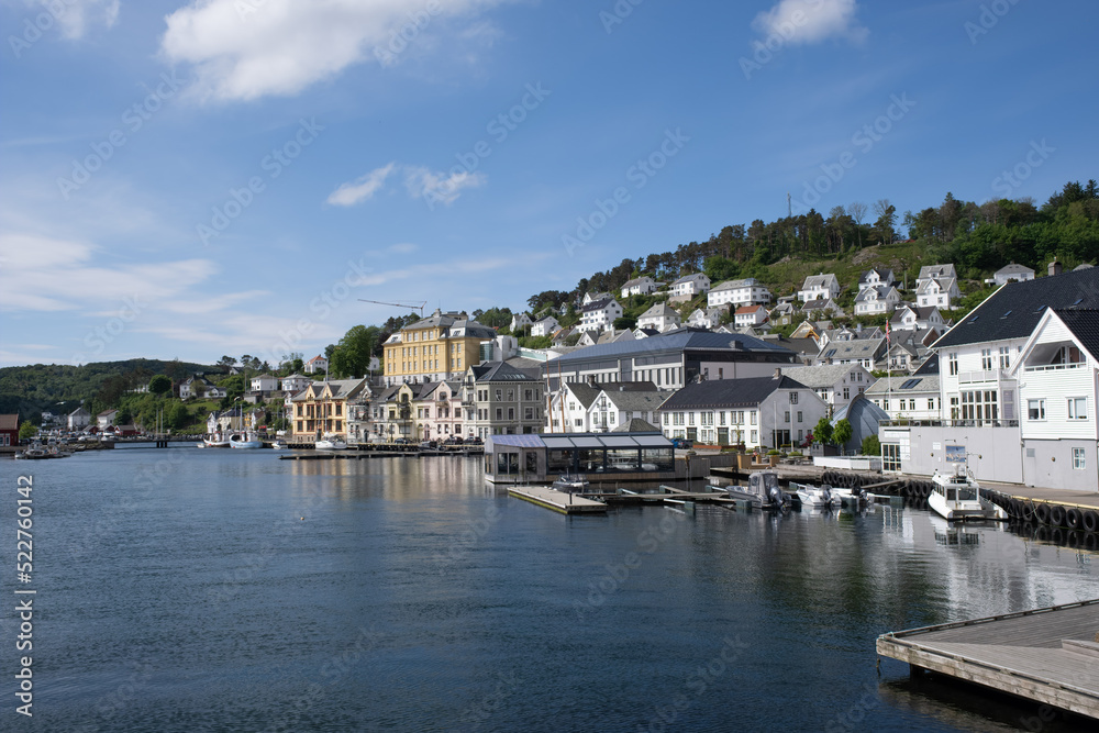 Farsund, Norway - May 30, 2022: Panoramic view of the city and many islands from a hill in a sunny spring day. A spectacular view to Lyngdalsfjorden and town suburbs. Trees, sunny day. Selective focus