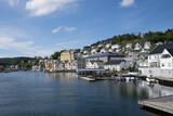 Farsund, Norway - May 30, 2022: Panoramic view of the city and many islands from a hill in a sunny spring day. A spectacular view to Lyngdalsfjorden and town suburbs. Trees, sunny day. Selective focus