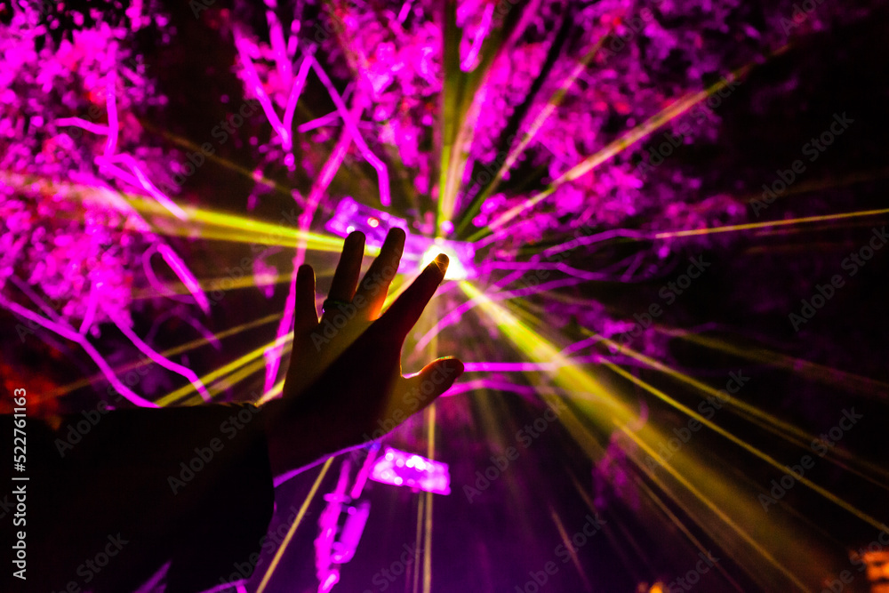 © Austockphoto - Rays of light from festival display shine through mans hand