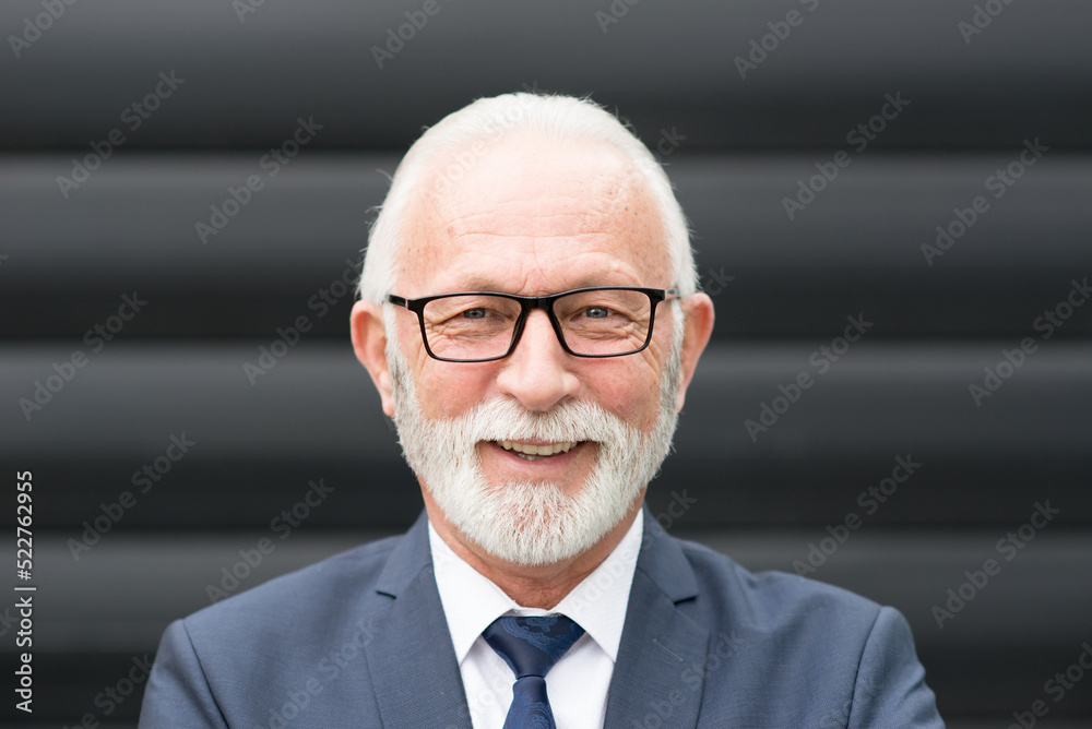 Senior smiling businessman in front of corporate office building Senior smiling businessman in front of corporate office building