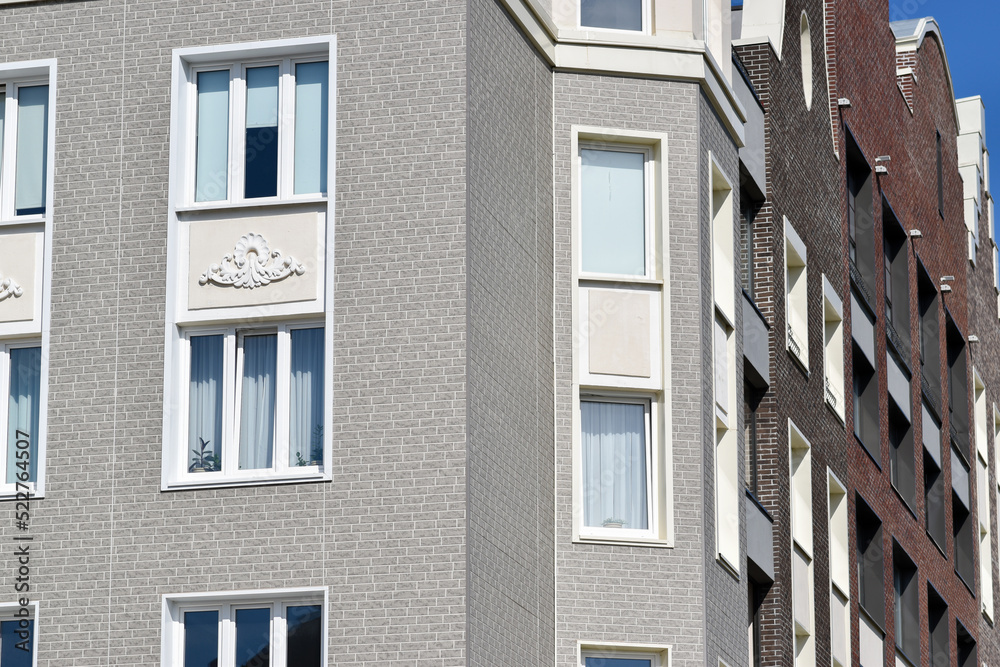 The stylish facade of a residential building with beautiful windows is a new multi-apartment residential quarter of European houses.