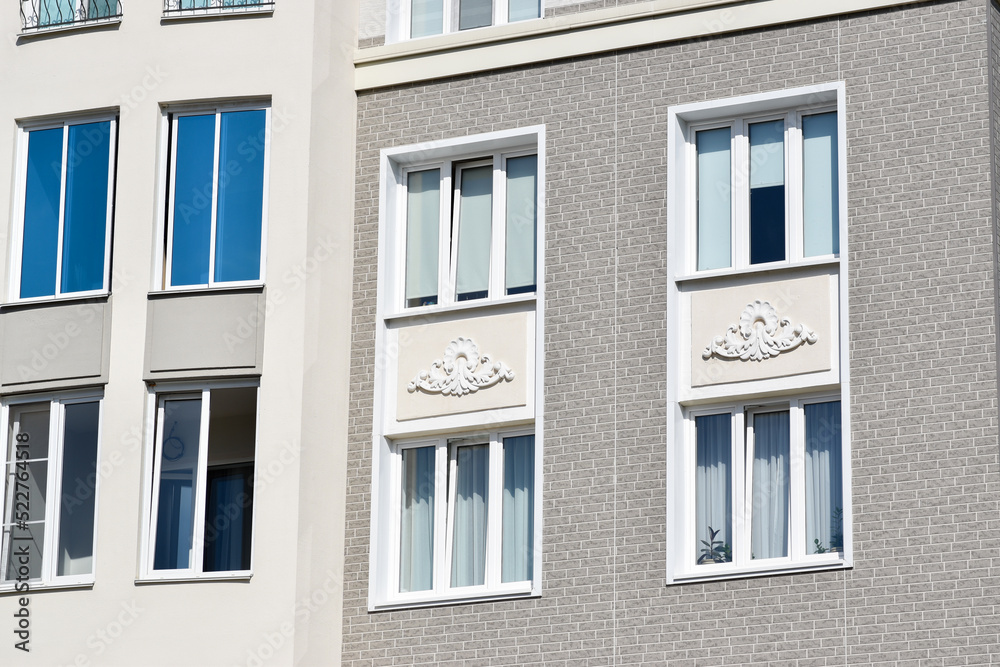 Stylish facade of a residential building with beautiful windows. Quarter of European houses. Abstraction in the city