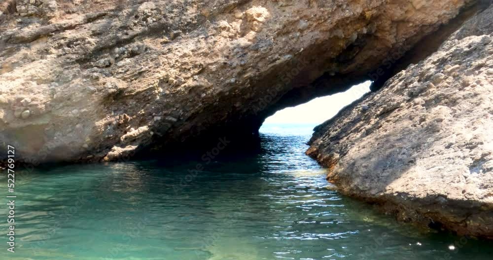Seacoast passage through the cave to the open sea. Summer adventure. Travel destination Greece. 4K footage. Seacoast passage through the cave to the open sea. Summer adventure. Travel destination Greece. 4K footage.