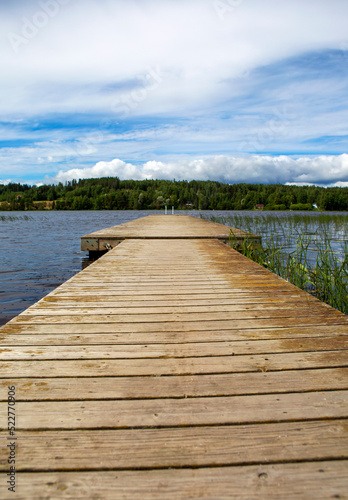 Empty pier on the lake shore, wooden long dock as a peaceful scenery and wallpaper concept image.