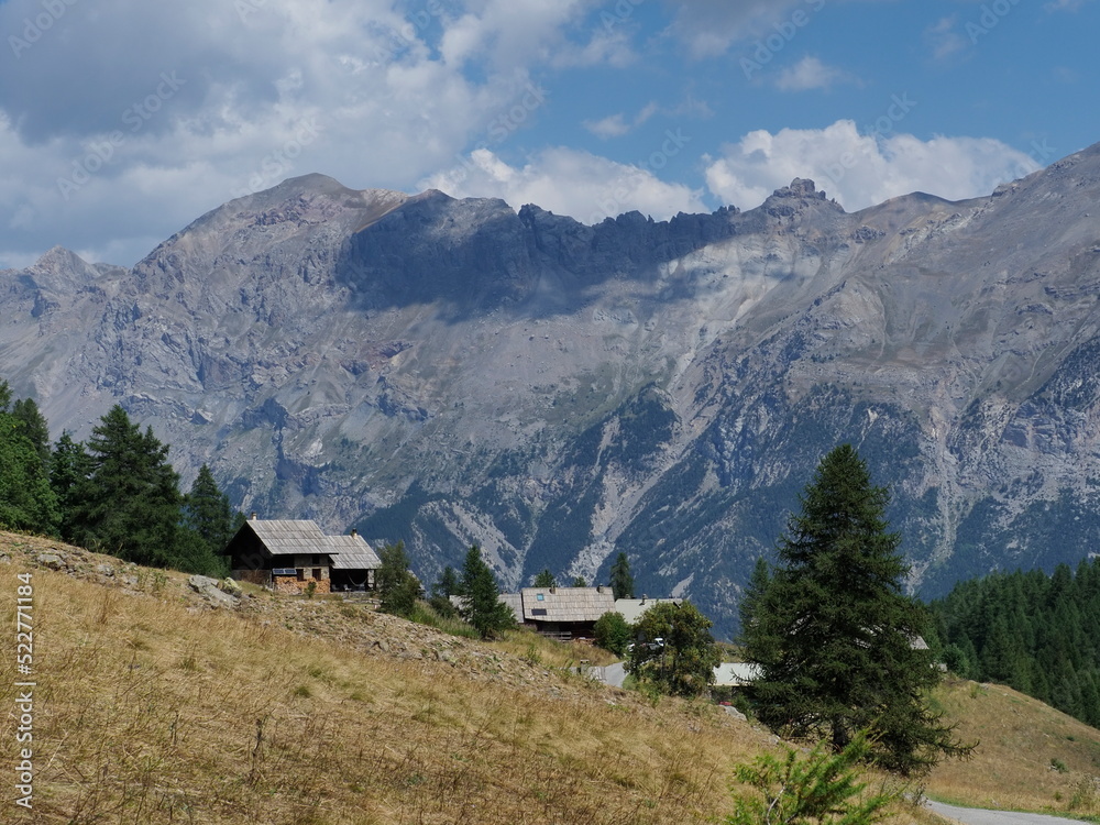 hameau en montagne dans les alpes, au milieu des alpages, sous un ciel bleu