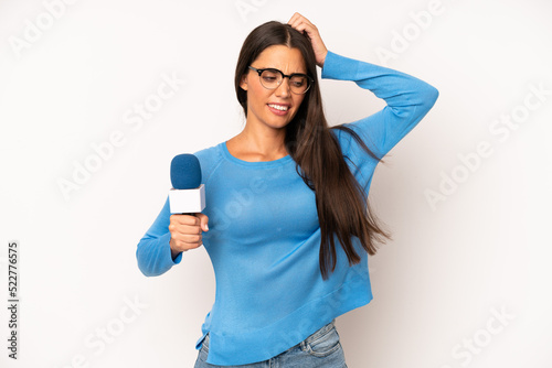 pretty hispanic woman smiling happily and daydreaming or doubting. presenter with a microphone concept photo