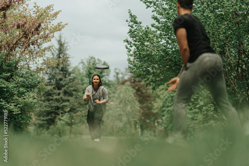 Fototapeta Naklejka Na Ścianę i Meble -  Couple playing frisbee in the park