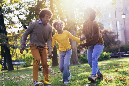 Happy family mother father and daughter on autumn walk in the park photo