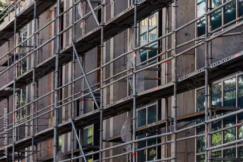 Scaffolding next to a new apartment building under construction. Metallic structure on a construction site