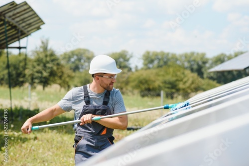 young worker cleaning solar panels.