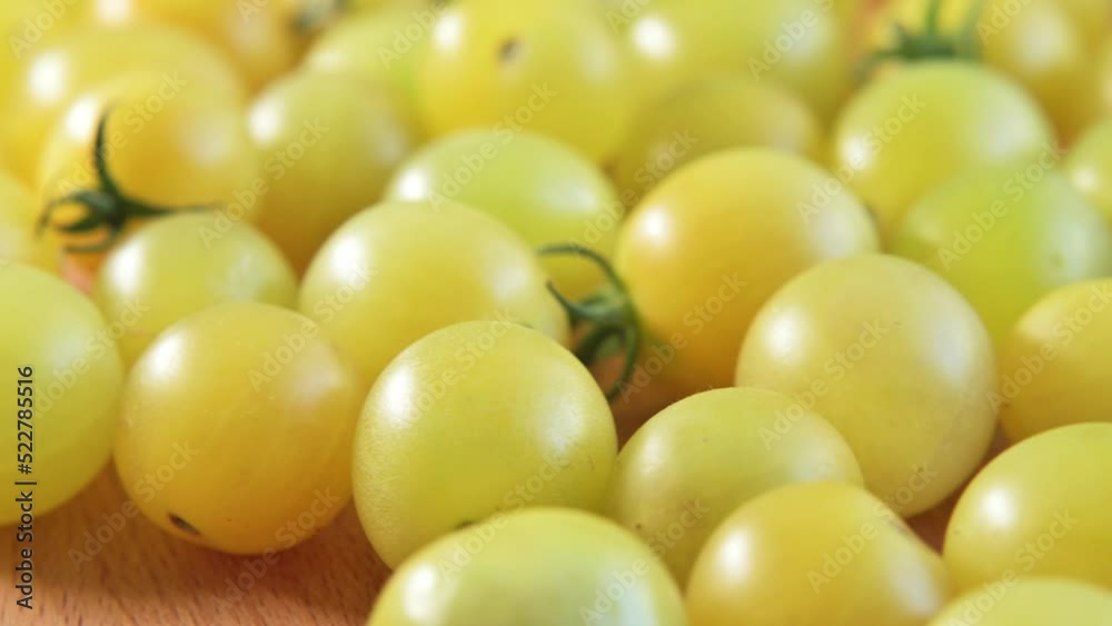Ripe yellow organic small cherry tomatoes rotate on wooden board top view. Delicious summer vegetable, healthy food, diet, salad ingredient. Tomatoes close up. Eco product. Footage 4K Ripe yellow organic small cherry tomatoes rotate on wooden board top view. Delicious summer vegetable, healthy food, diet, salad ingredient. Tomatoes close up. Eco product. Footage 4K