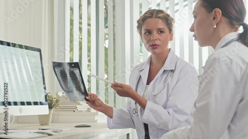 Wallpaper Mural Female doctor holding chest x ray scan and speaking with colleague while working together in medical office Torontodigital.ca