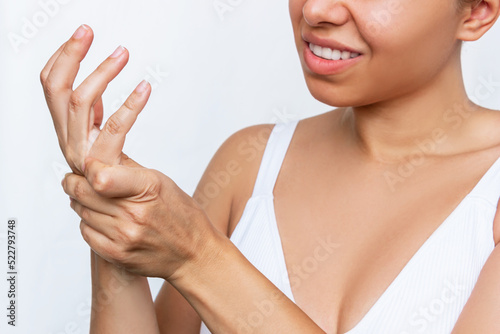 Numbness of the limbs. Pain in the hand, palm and joints. A young woman holding a wrist in her hand isolated on white background. Wrist injuries, carpal tunnel syndrome, neuralgia. Dislocated wrist photo
