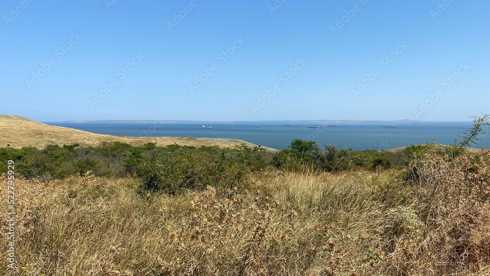 Seascape overlooking hills with dry grass