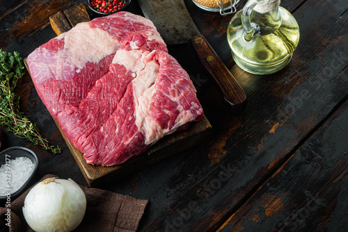 Brisket flat cut, raw beef brisket meat,with ingredients for smoking  making  barbecue, pastrami, cure, on old dark  wooden table background,  with copy space for text photo